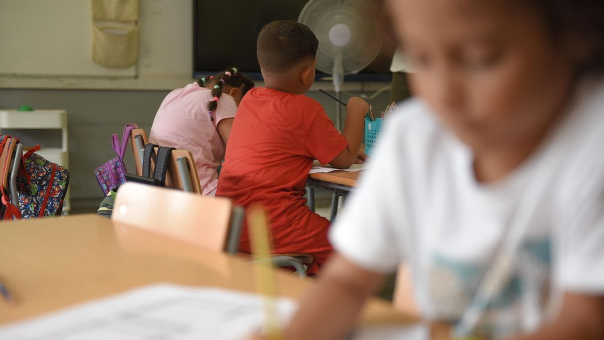 Varios niños en las mesas del colegio realizan ejercicios al inicio del curso escolar