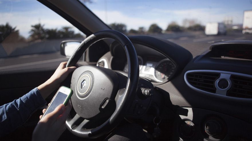 Conductor con teléfono móvil, conducción, tráfico, seguridad vial.