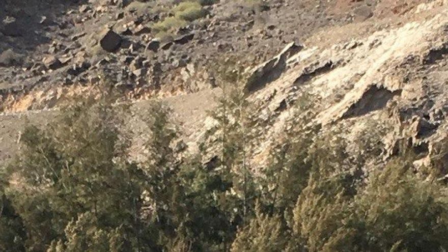 Momento en que los migrantes abandonan la playa de Venguera tras desembarcar de la patera este sábado