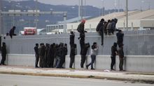Un grupo de migrantes trata de saltar la valla del puerto de Patras, Grecia.