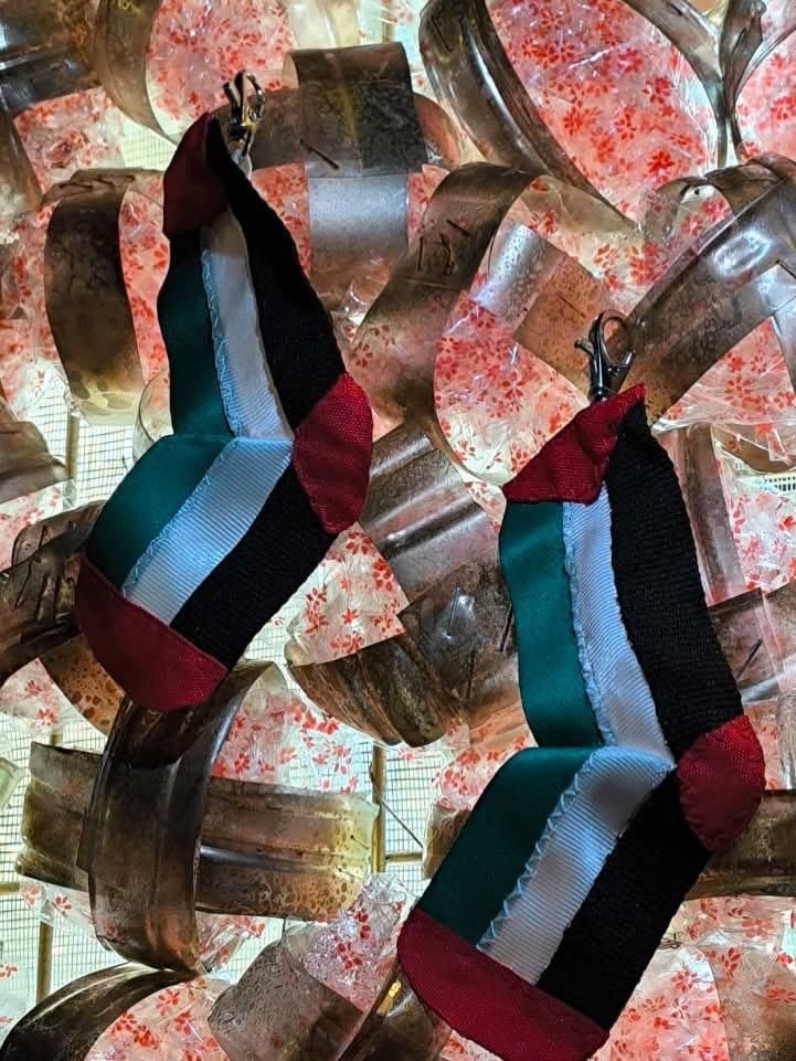 Detalle de adornos hechos por Rosi Riesgo; dos calcetines que recuerdan a los niños y niñas asesinados en Gaza en el actual genocidio.