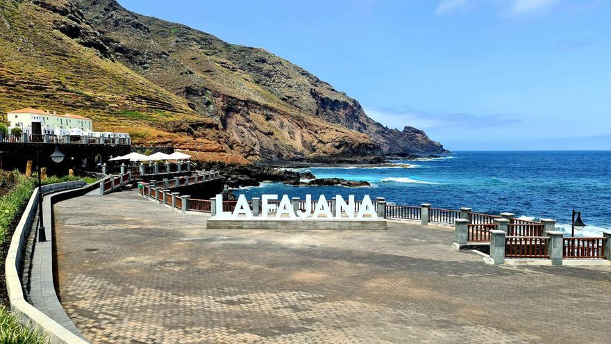 Cartel de letras de gran tamaño con el nombre de La Fajana desde el que se aprecia el perfil del litoral del municipio y La Punta de la Gaviota.