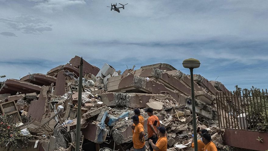Personas observan un dron durante operaciones de rescate en una zona afectada por los terremotos, este domingo, en La Guaira (Venezuela).