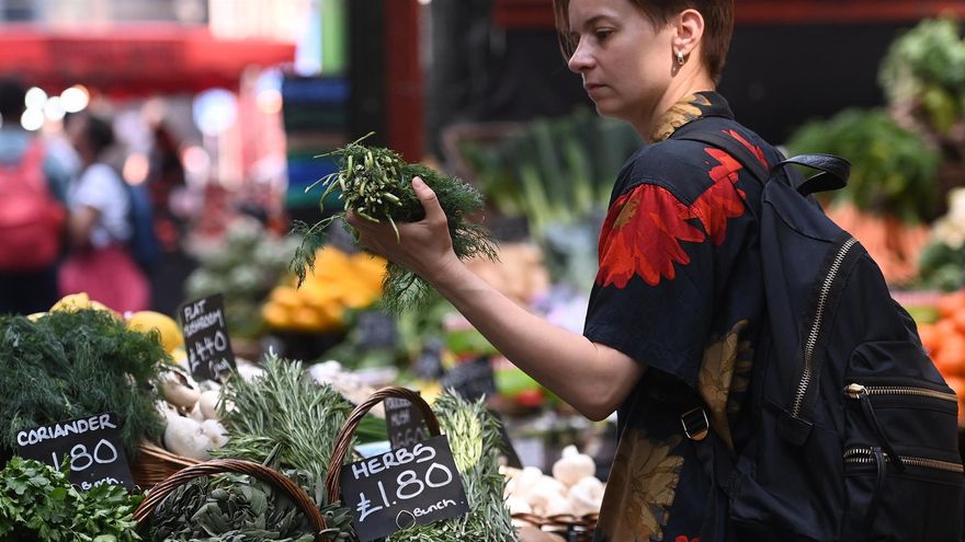 Una mujer revisa verduras en un mercado en Londres el 20 de julio