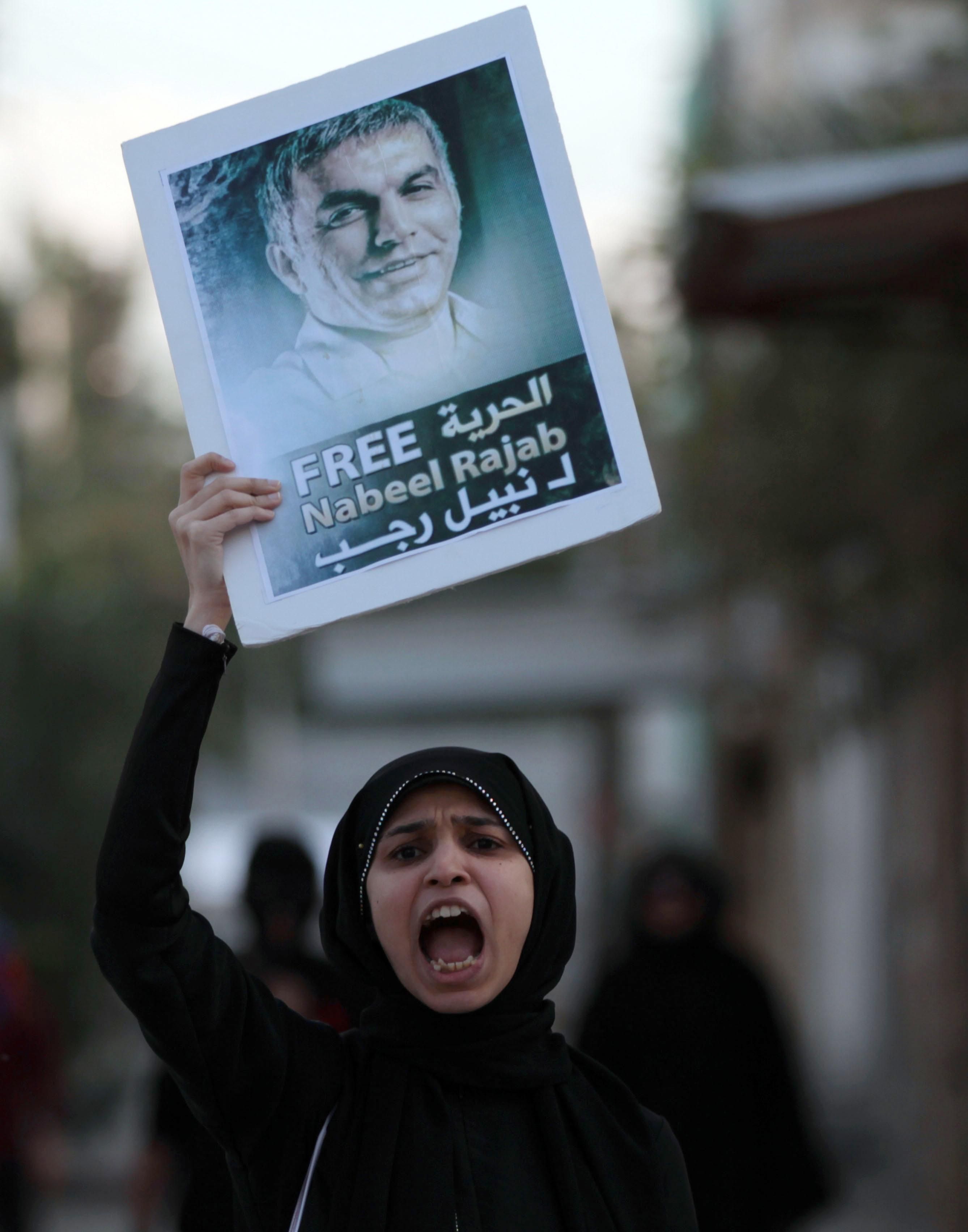 DICIEMBRE. Los ataques, el acoso y la persecución de defensores y defensoras de derechos humanos, así como el uso excesivo de la fuerza en las manifestaciones, tratan de silenciar las voces de miles de activistas  que en todo el mundo luchan contra las injusticias. Desgraciadamente, a veces lo consiguen, pero nuevas voces surgen. En la foto, una manifestante grita consignas a los antidisturbios mientras sostiene la foto del activista por los derechos humanos encarcelado, Nabeel Rajab en Barhéin. #libertadReunion // © AP Photo/Hasan Jamali