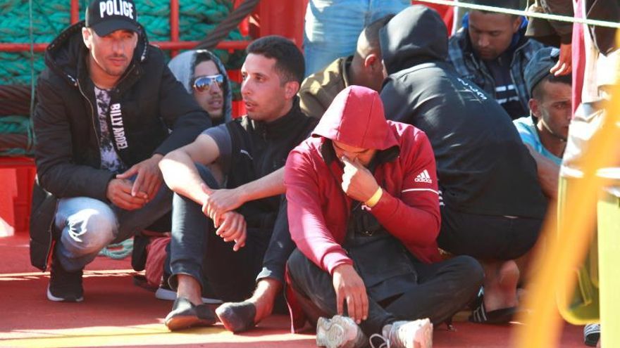 Varios de los 73 inmigrantes, todos ellos varones de origen magrebí, que han sido rescatados por el buque de Salvamento Marítimo "Guardamar Concepción Arenal", a su llegada al puerto de Algeciras donde serán atendidos por Cruz Roja y trasladados por la Guardia Civil.