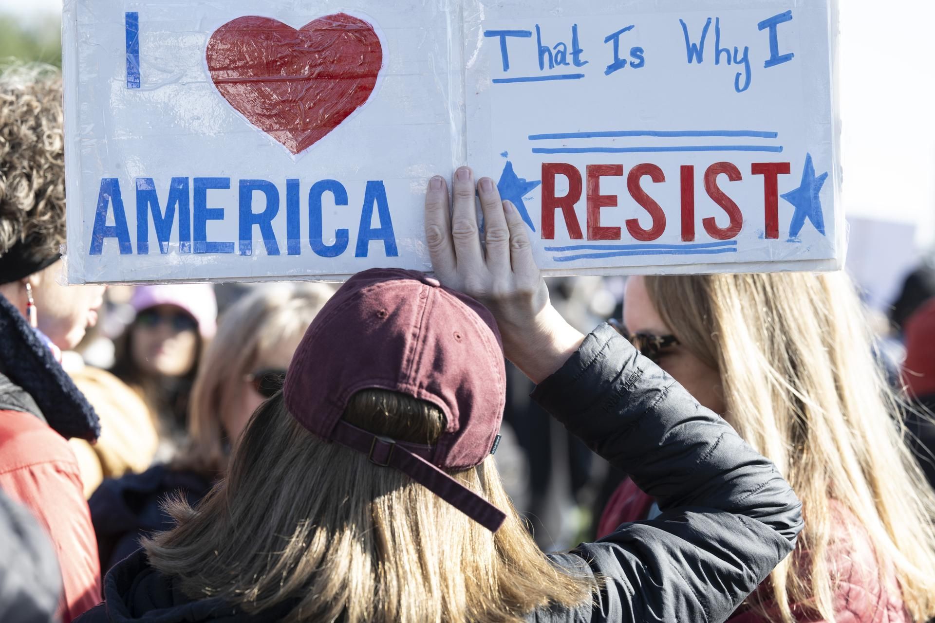 Una mujer porta una pancarta en la que puede leerse "Amo a América, por eso me resisto" en la manifestación de Washington.
