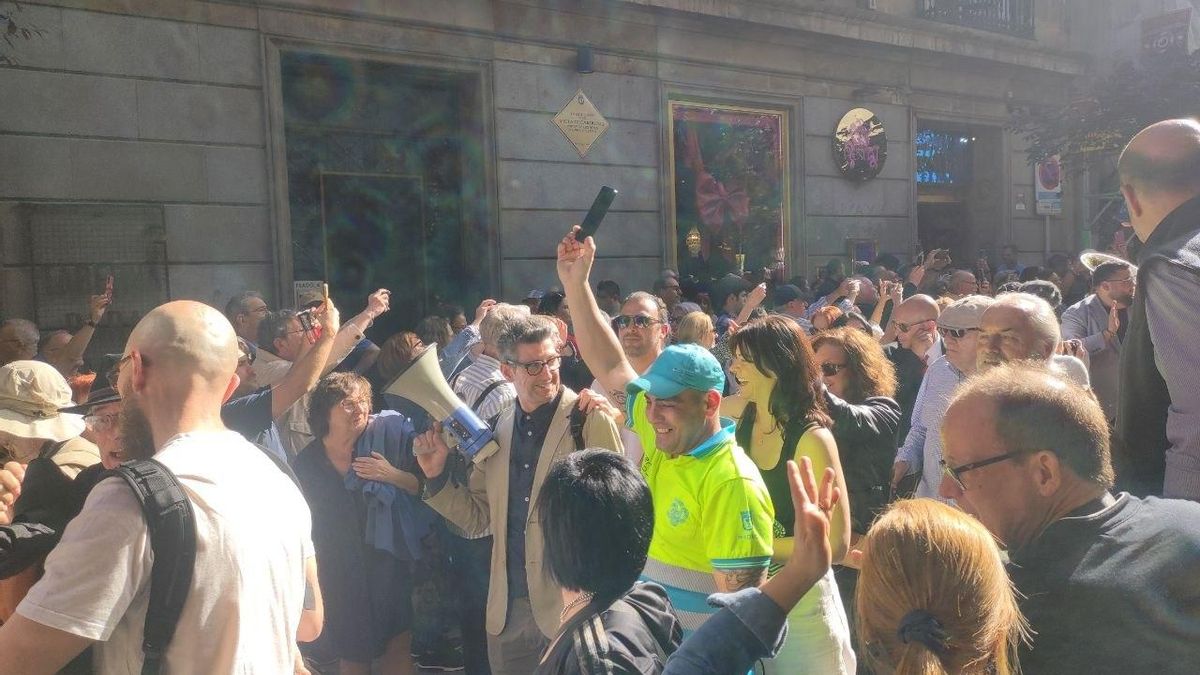 Un trabajador de limpieza municipal detiene un momento sus tareas para unirse al concierto callejero, grabarlo y disfrutar de él. A su lado, megáfono en mano, el empleado y alma del Café Central, Juantxu Bohigues.