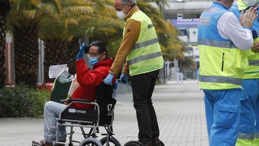 Un paciente es acompañado por un voluntario del hospital de Ifema tras recibir el alta este sábado, vigésima octava jornada del estado de alarma decretado por el gobierno para intentar frenar el avance de coronavirus.