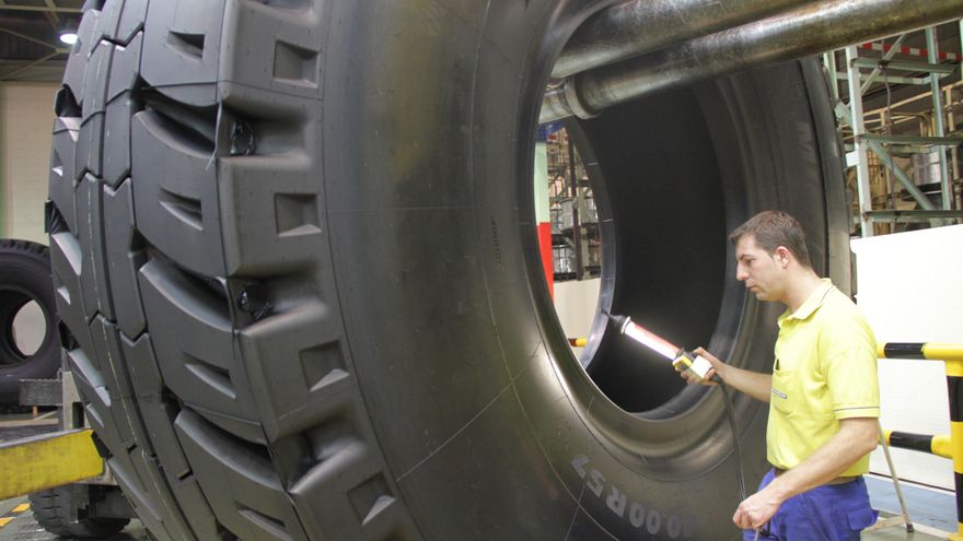 Un operario realiza una verificación en un neumático de gran tamaño.