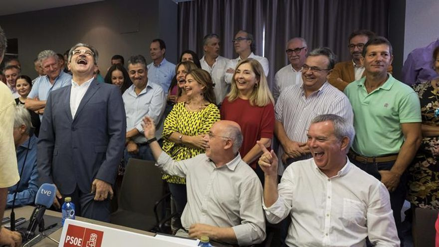 El presidente de Nueva Canarias, Román Rodríguez (i), tras firmar la alianza con el secretario general del PSOE de Canarias, José Miguel Pérez, se rie tras una broma de su compañero de partido y presidente del Cabildo insular Antonio Morales (c) y del miembro del PSOE, Sebastián Franquis (d). (EFE/Ángel Medina G.).