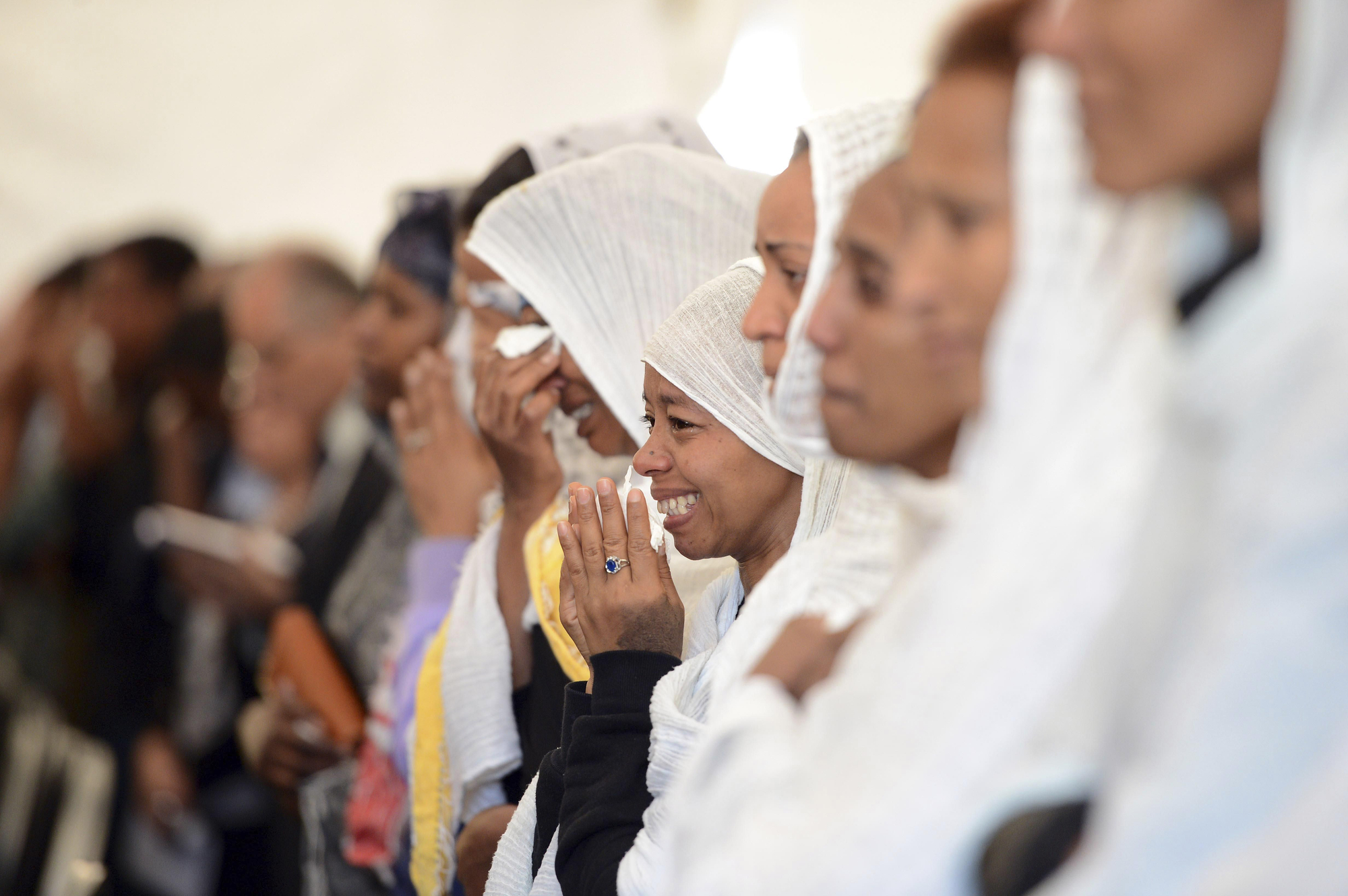 Lloros de varias mujeres durante el funeral de las víctimas del naufragio en el que fallecieron 800 personas, según Acnur, frente a las costas de Libia. Este jueves se ha producido el entierro de los 24 migrantes que se ahogaron mientras intentaba llegar a las costas del sur de Italia/ Foto: AP - Rene Rossiganud)
