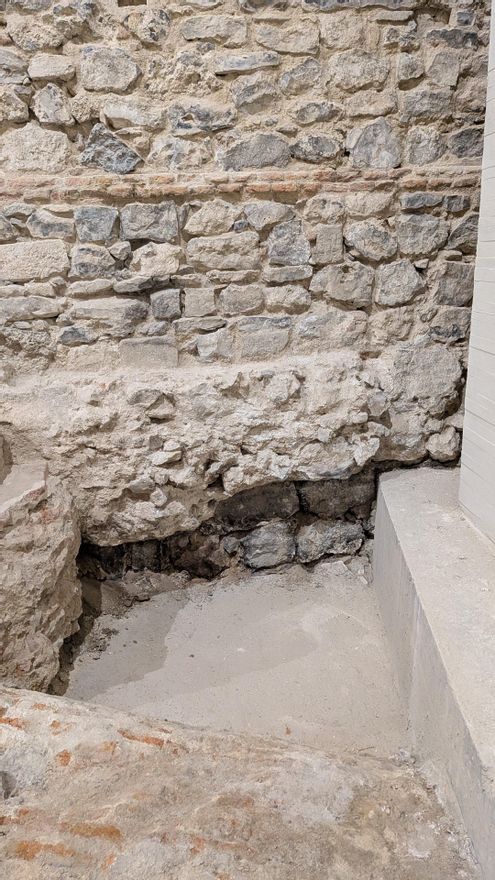 Restos de la muralla árabe emiral (zona oscura, al pie del muro) en la Galería de las Colecciones Reales de Madrid