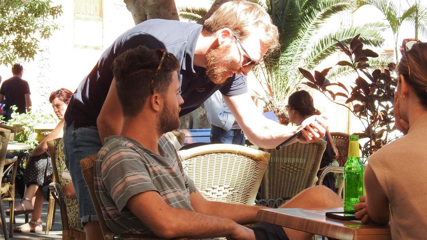 Varios jóvenes en Garachico comprueban el mensaje de alerta recibido este jueves