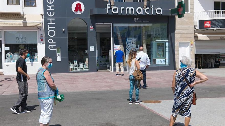 Personas por fuera de una farmacia en Canarias, guardando la distancia de seguridad