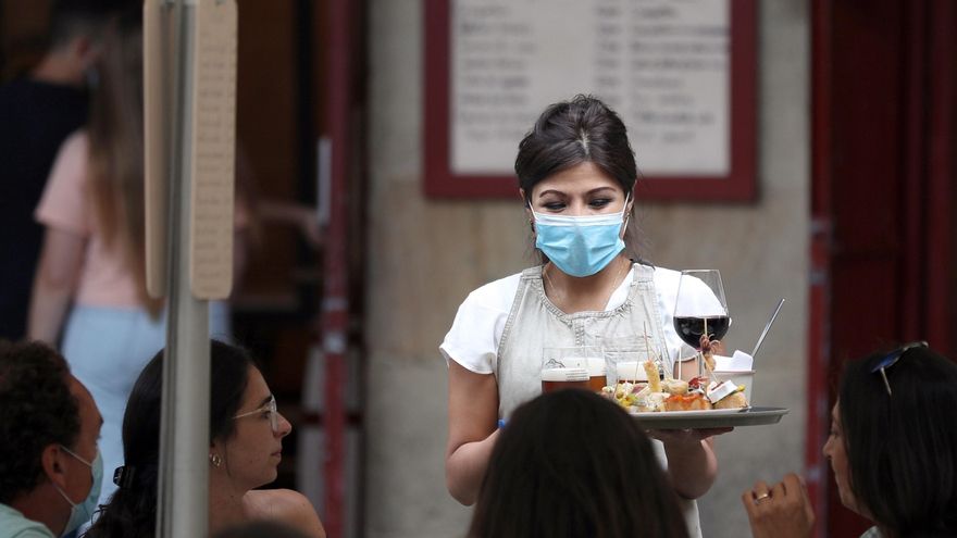 -Una camarera atiende a unos turistas en Bilbao. EFE/LUIS TEJIDO/Archivo