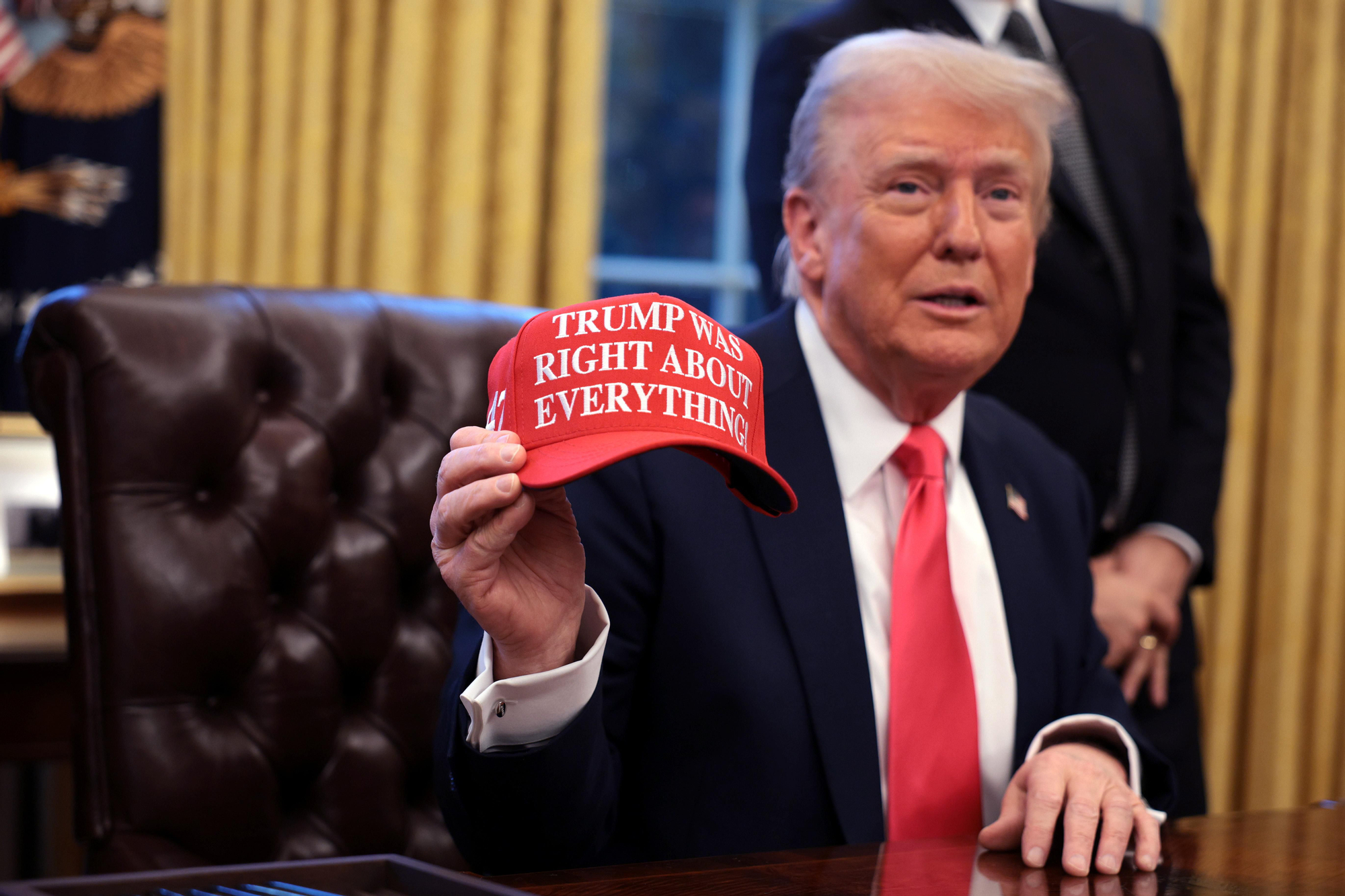 El presidente de Estados Unidos, Donald Trump, sostiene una gorra en la que se lee "Trump tenía razón en todo", en el Despacho Oval de la Casa Blanca el 25 de febrero de 2025 en Washington, DC.