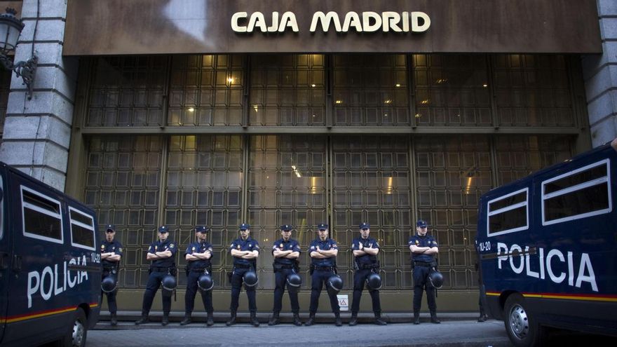 Policías vigilan una sede de Caja Madrid, en mayo de 2012./ AP