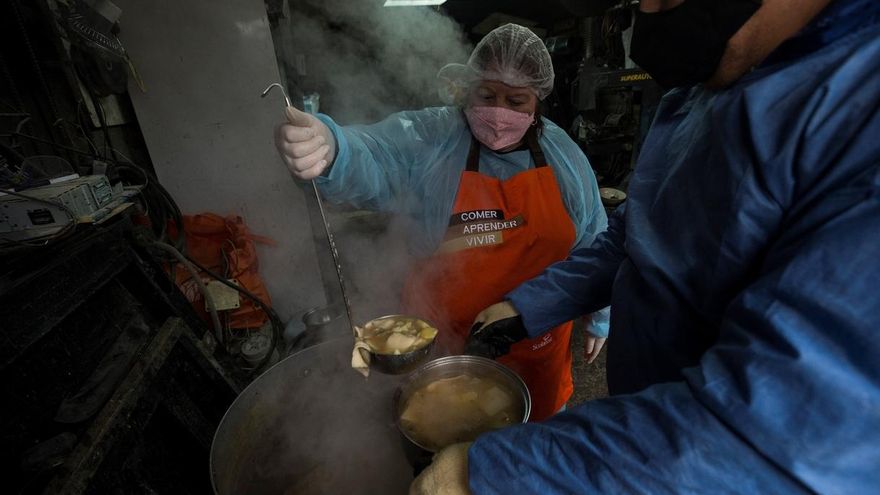 Vecinos preparan almuerzos el 30 de junio de 2020 durante una olla común, destinada a ayudar a las familias vulnerables y a las personas sin techo del sector afectadas por la pandemia de COVID-19, en la comuna de Conchalí, en Santiago (Chile).