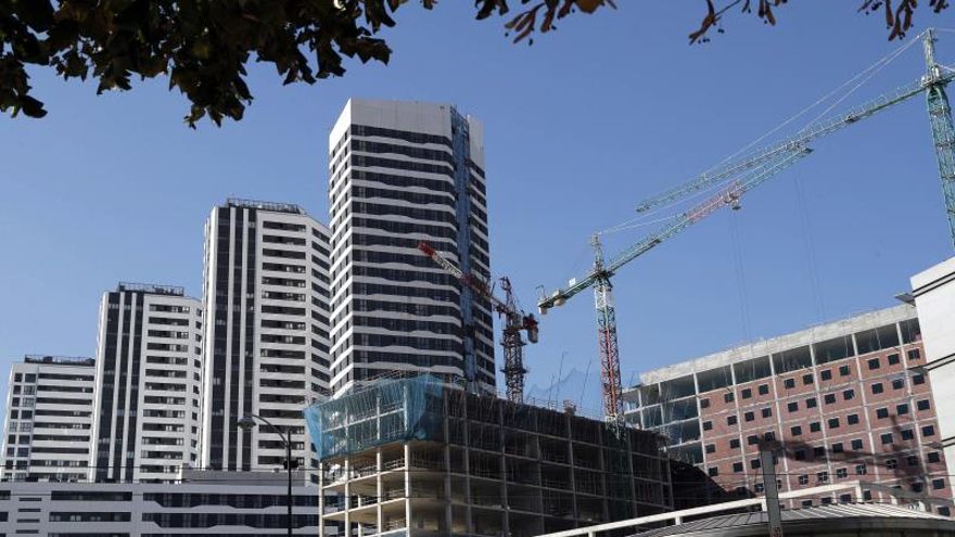 Un edificio en construcción junto a viviendas residenciales en Bilbao.