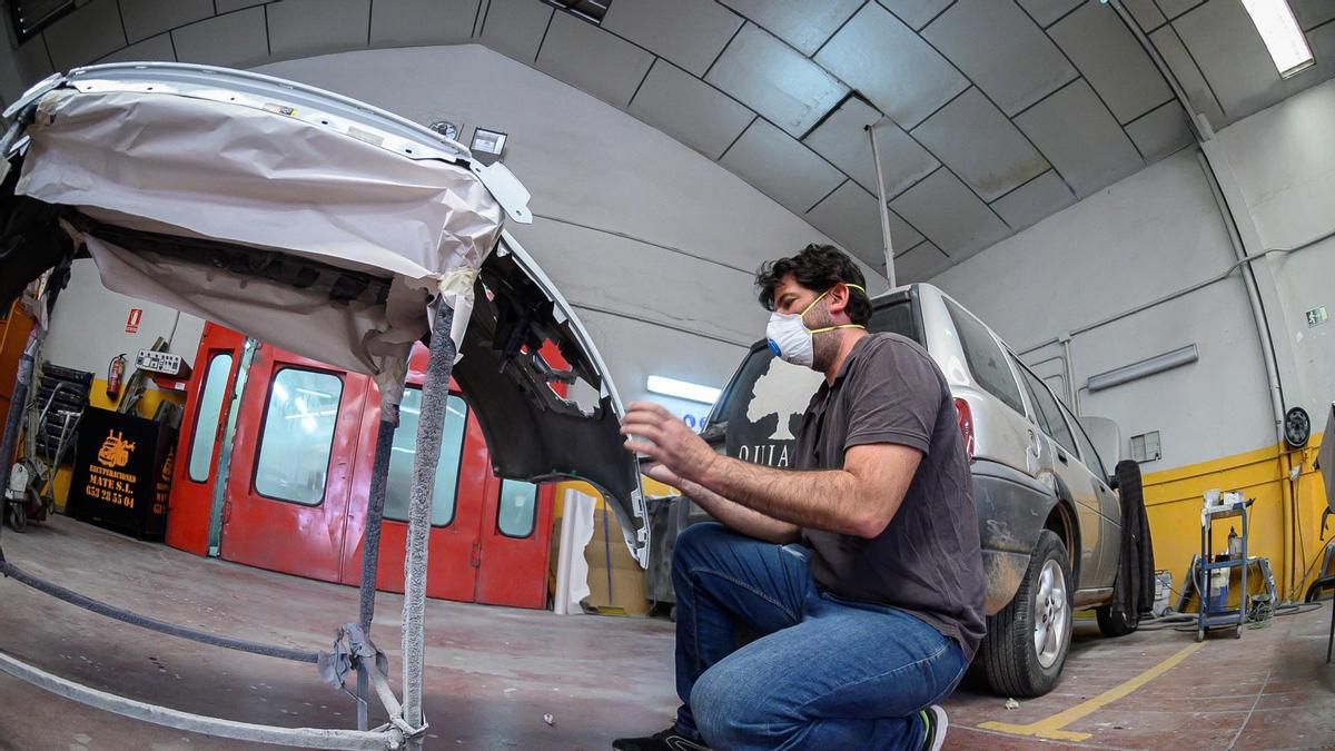 Un empleado trabaja en un taller mecánico en Alcalá de Henares. EFE/Fernando Villar/Archivo
