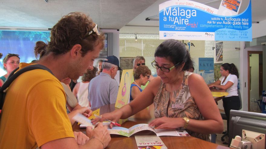 Archivo - Turistas informándose en una oficina de Málaga. Imagen de archivo.