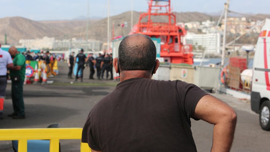 Un hombre busca en el muelle de Arguineguín a su familiar, que partió en patera desde Dajla hacia Europa