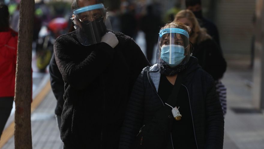 Dos ciudadanos protegidos con mascarilla y careta caminan por el principal corredor peatonal del centro en Santiago (Chile), en una fotografía de archivo. EFE/Elvis González