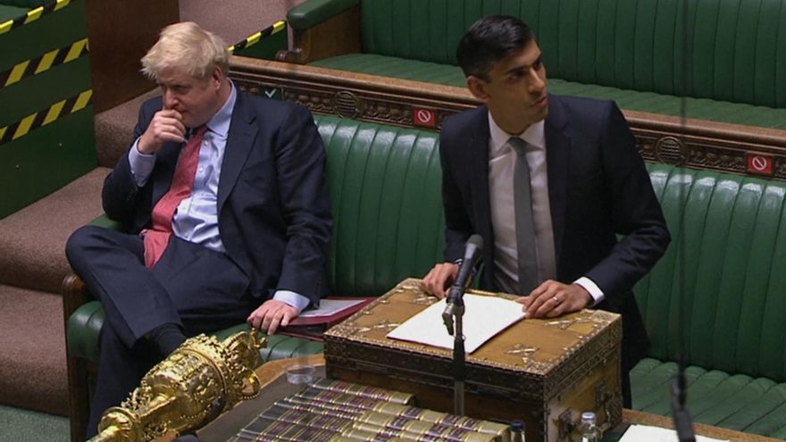 El primer ministro británico,Boris Johnson, sentado al lado del ministro de Finanzas, Rishsi Sunak