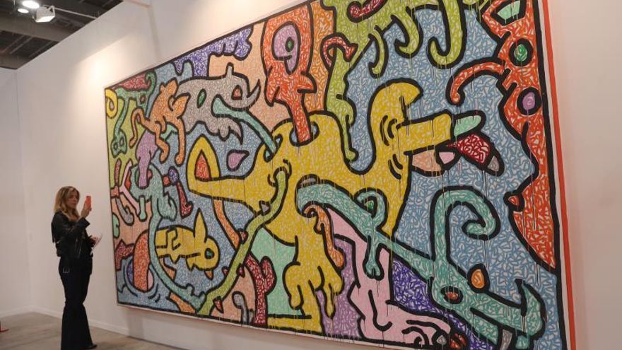 Una mujer observa una obra del artista estadounidense Keith Haring .