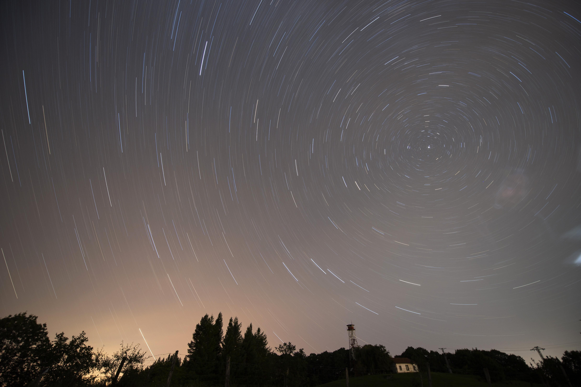 Fotografía de larga exposición durante la lluvia de estrellas de las Perseidas sobre la localidad cántabra de Comillas en la madrugada del viernes. EFE/Pedro Puente Hoyos