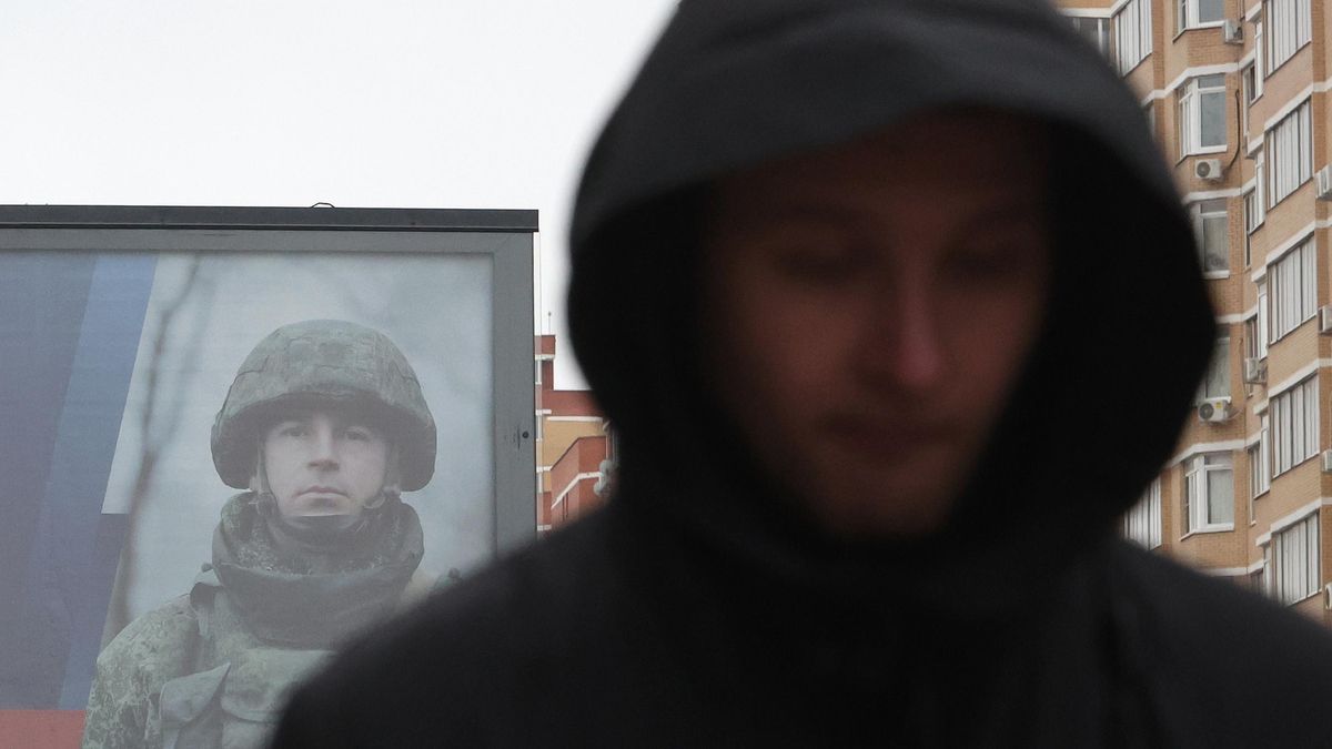 Un hombre camina en Moscú junto a un cartel de reclutamiento del Ejército ruso
