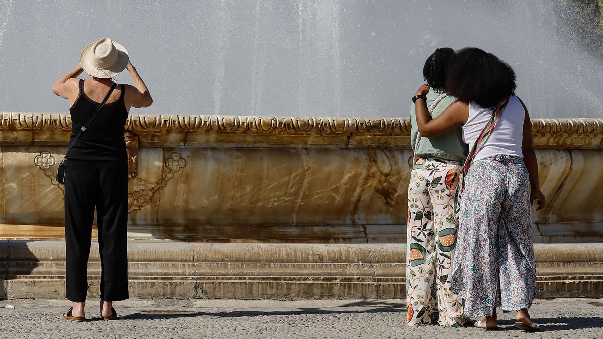 Unos turistas toman fotos en la plaza de España de Sevilla