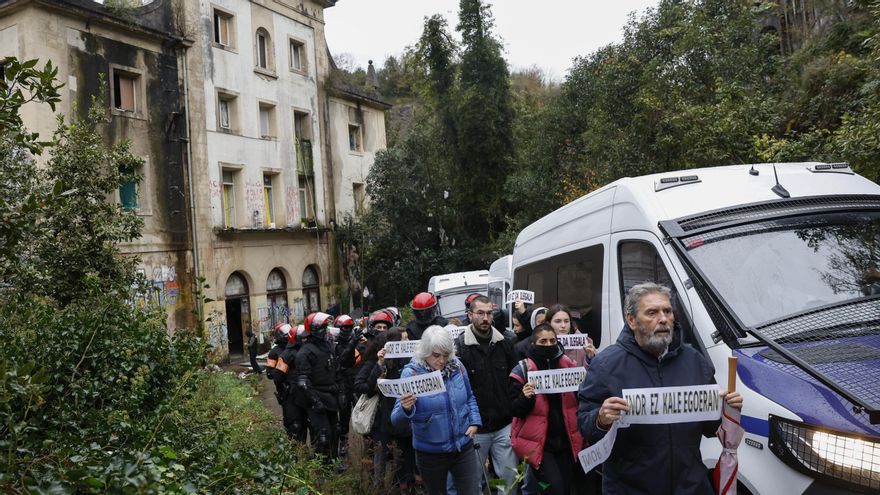 Manifestantes con carteles de "Inor ez kale gorrian" ("Nadie en la calle") durante el desalojo de 111 personas que vivían en la antigua escuela de Martutene, en Donostia