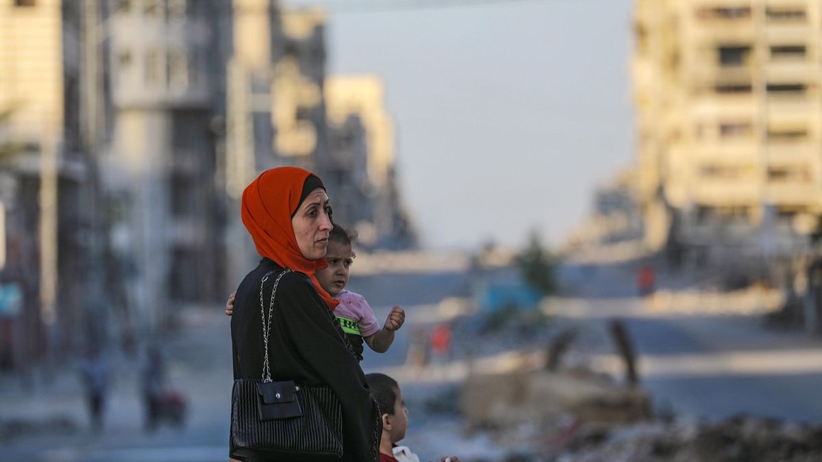 Una madre palestina lleva a su hija por la calle Al Jalaa en la ciudad de Gaza, Franja de Gaza, 06 de octubre de 2025.