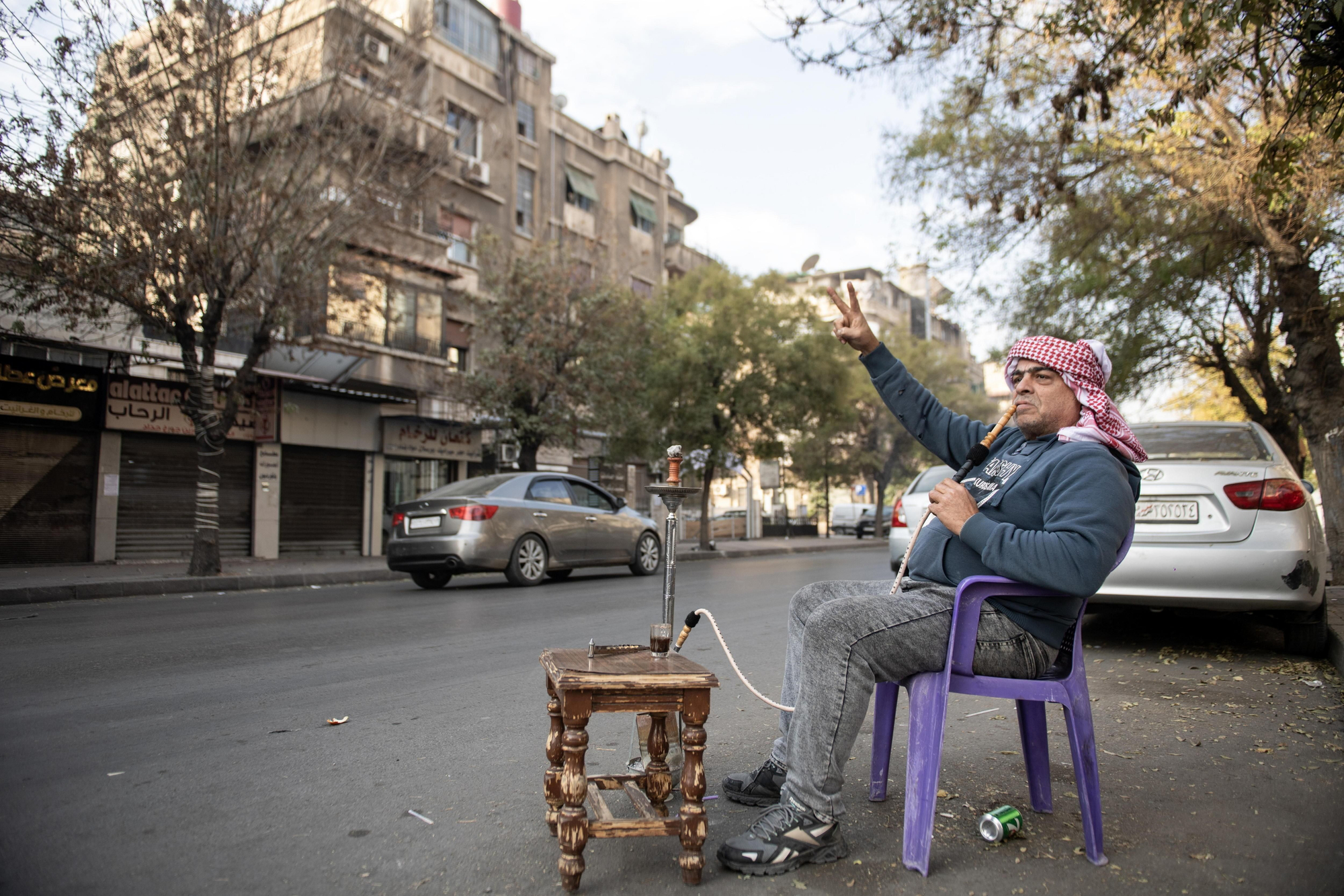 Un hombre fuma una cachimba mientras apoya la celebración de la ciudadanía siria tras la entrada de los rebeldes a Damasco, este domingo. EFE/EPA/HASAN BELAL