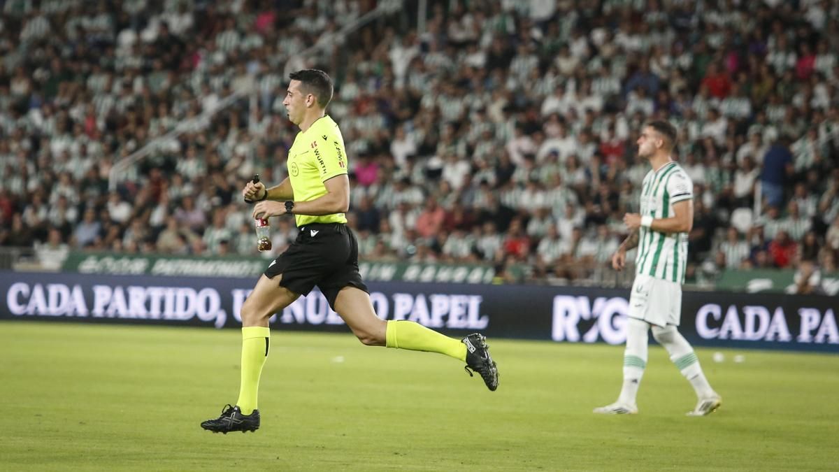 El árbitro del partido con la botella lanzada desde el fondo sur