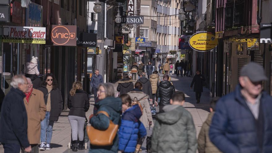 Gente paseando junto a comercios de Torrelavega