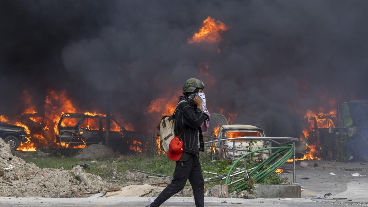 Un manifestante frente al Tribunal Supremo en llamas