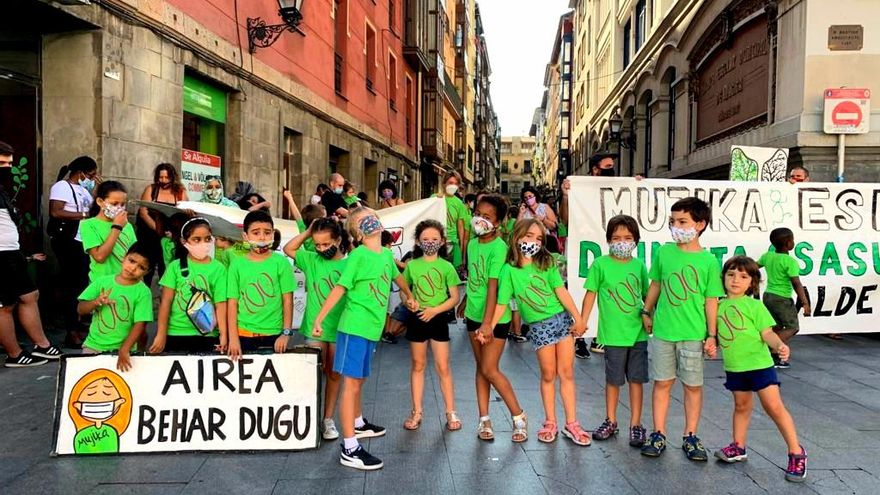 Alumnos del colegio Mujika con un cartel en el que se lee "Necesitamos aire" en euskera