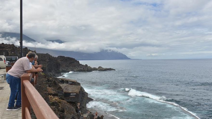 Varios personas contemplan las piscinas naturales de La Maceta, en el Valle de El Golfo en La Frontera, en las que hay numerosos bañistas.