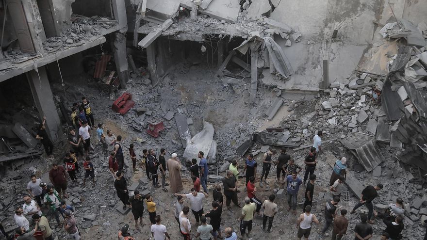 Palestinos buscan cadáveres y supervivientes entre los escombros de un edificio residencial arrasado por un ataque aéreo israelí en Yan Yunis.