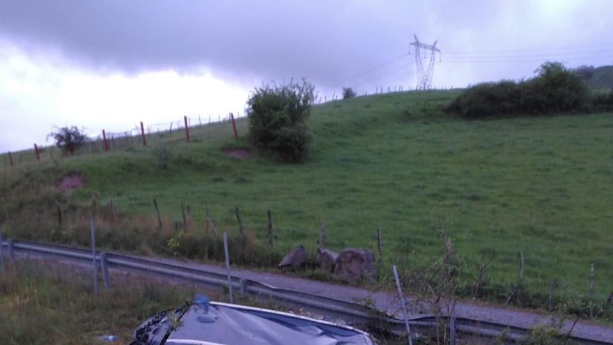 Bomberos voltean el coche volcado.