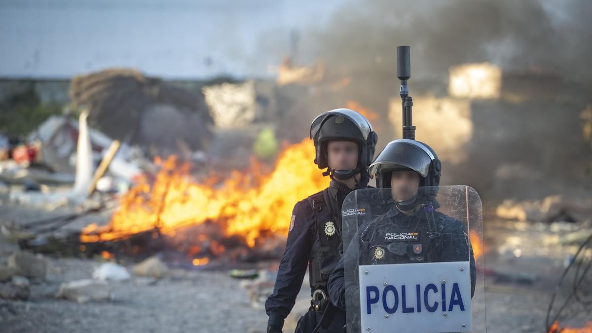 Policías durante la quema de las cabañas y pertenencias de los migrantes en la playa del Trampolín.