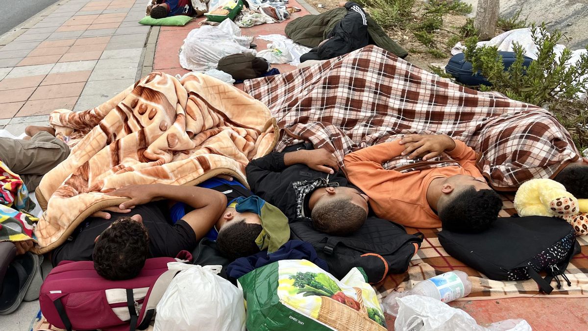 Migrantes duermen en la calle cerca de la explanada de Loma Colmenar en Ceuta a la espera de poder acceder al campamento temporal.