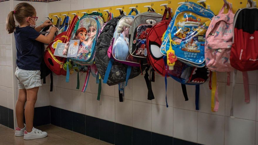 Una niña deja su mochila junto a otras en el inicio de curso.