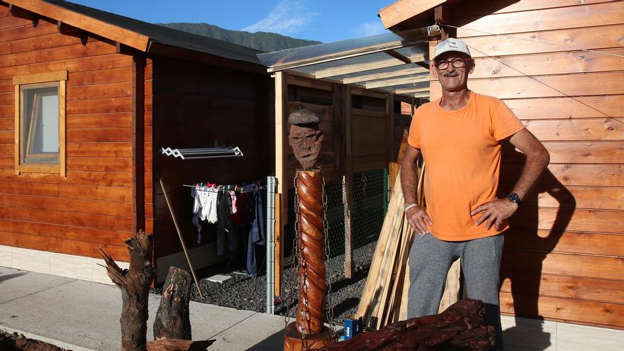 Jorge Luis también perdió su vivienda habitual por el volcán. En la imagen, posa junto al busto de piedra hecho por él mismo frente a su nueva casa de madera en El Paso, La Palma