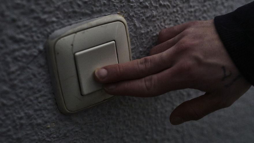 Un hombre toca un interruptor de luz