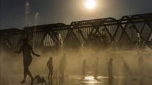 Varias personas se refrescan en las fuentes de Madrid Río. / Efe