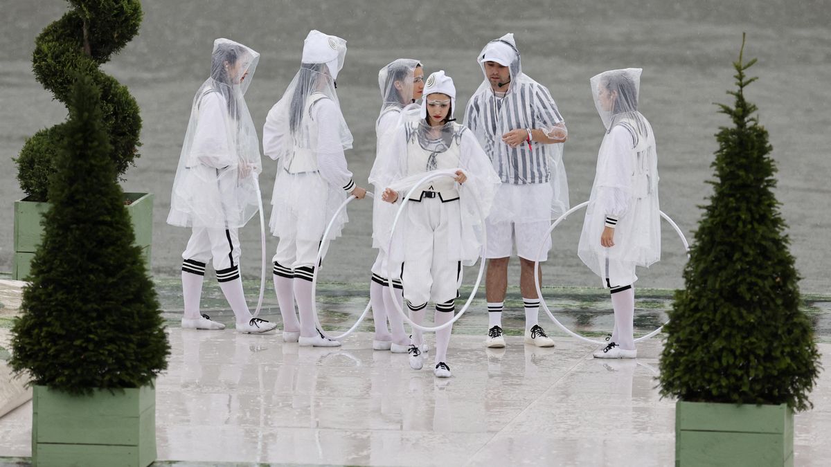 Artistas con aros sobre una plataforma flotante en el río Sena durante la ceremonia de apertura.